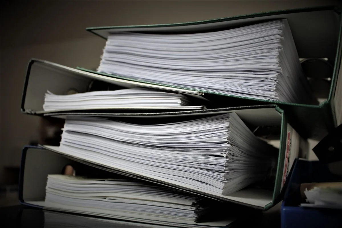 Stacked binders containing paper documents; stock photograph, not a Gemini screenshot.