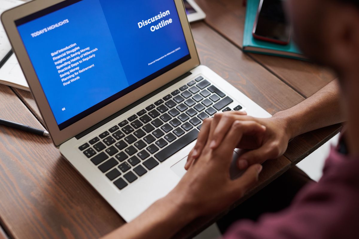 A person reviewing a presentation outline on a laptop.